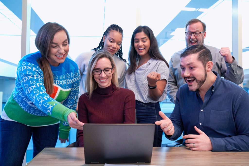 Group of happy customers looking at laptop together