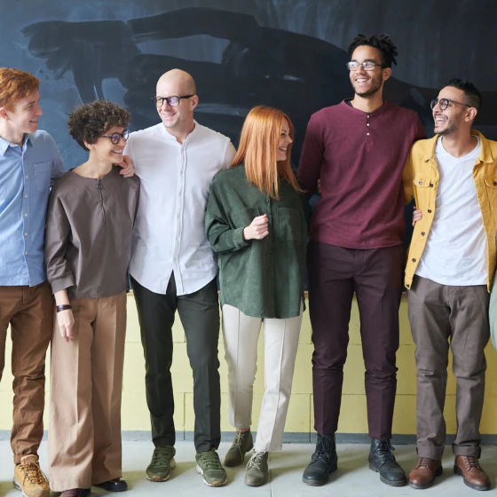 Group of cheerful people standing infront of blackboard