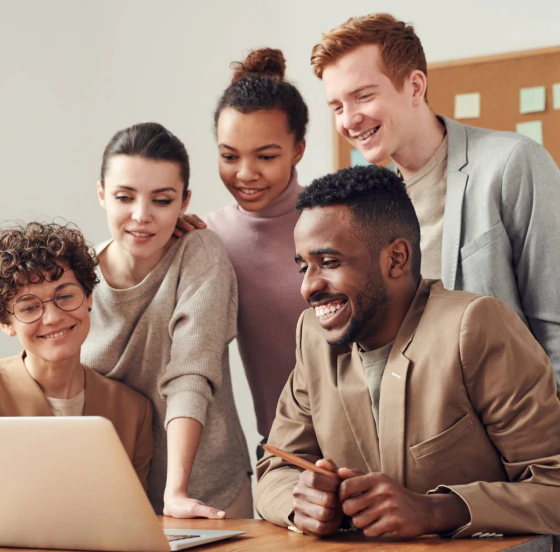 Group of people in beige looking at laptop