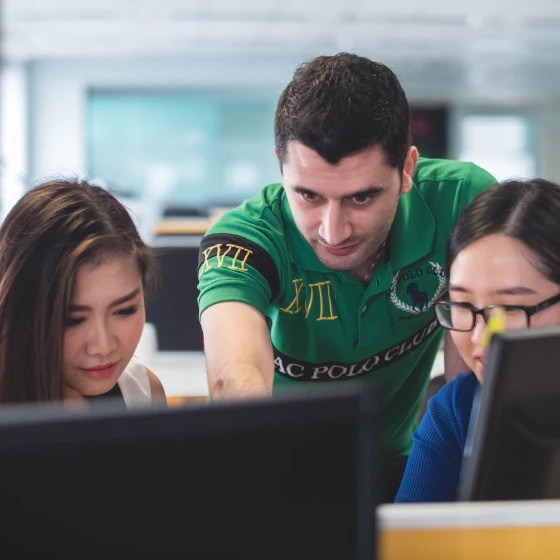 Man showing 2 students reporting on screen